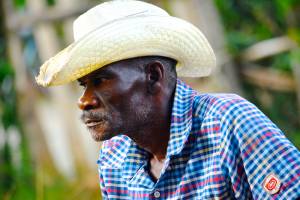 A farmer listens as his neighbors tell of being pushed from their land in Northeast Haiti