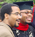 Photograph of two men, one in graduation robe and hat.