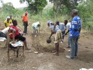 One-day workshop in the community of Gwanit, where Road to Life Yard team member Durosier Joachim (left side of bed with hoe) shows participants how to finish a raised bed.