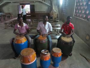 Men from the young adults of the church, playing the drums as choir practice is about to start.