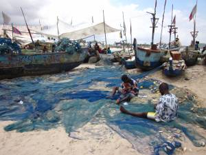 Fishermen in Ghana mending their nets, after a long day out at sea