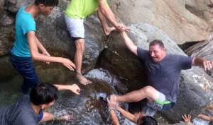 Aboriginal youth from Bi Ho Church helps an American mission team member up the river
