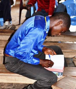 Just after purchasing his first Bible, Peter Kanku carefully writes his name in it.