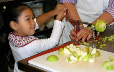 A girl peels and chops a locally grown apple made available through a Presbyterian Hunger Program-supported ministry. (Photo courtesy of Presbyterian Hunger Program)