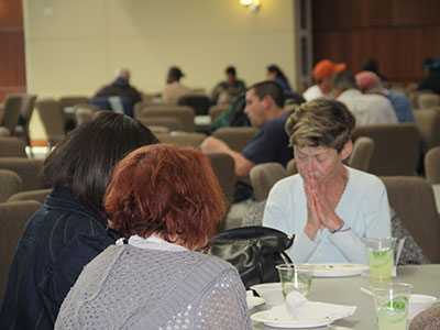 Community meals can bring together people from all walks of life. Guests of First Presbyterian Church Fort Worth pray and reflect druing their meal. (Photo courtesy of First Presbyterian Church of Fort Worth)