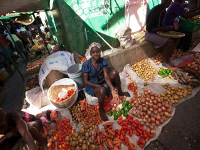 A woman sells produce in the market in Jacmel. (Photo by Daniel Morel)