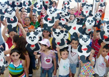 Children show off their art work at a JMP sponsored summer camp in Kessab, Syria.