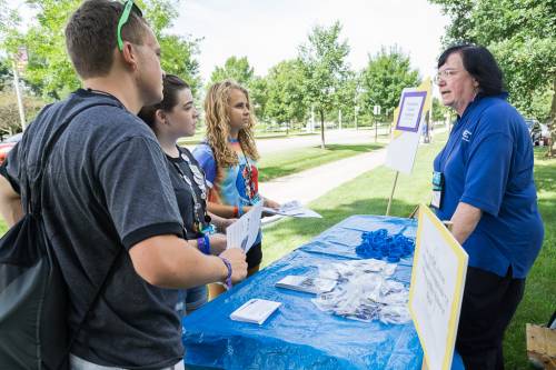 Students from Peaks and Prairies and Chicago presbyteries, Eli, Abby and Hannah, speak with Beth Snyder of Presbyterian Disaster Assistance during the Triennium advocacy walk. (Photo by Gregg Brekke)