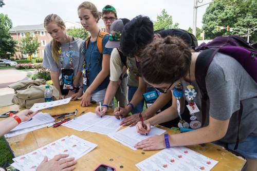 Students sign a petition asking for fair wages for strawberry farm workers during the Triennium advocacy walk. (Photo by Gregg Brekke)