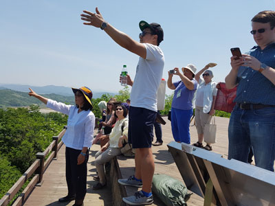 Workshop participants on Mt. Soi look out over to hills on the other side of the border into North Korea