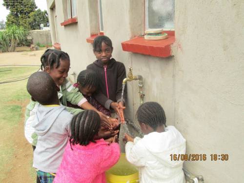 Children gather water at one of the school’s taps. (Photo by Talkmore Chilanga)