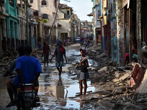 A girl walks on a street damaged in Hurricane Matthew, in Jeremie, in western Haiti, on October 7, 2016. The full scale of the devastation in hurricane-hit rural Haiti became clear as the death toll surged over 400, three days after Hurricane Matthew leveled huge swaths of the country's south. (Photo by Hector Retamal/AFP/Getty Images)