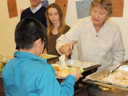 Volunteers at USpiritus's Thanksgiving dinner serve in the lines and help seat the kids and guests so that the staff can sit with the kids and enjoy the meal. (Photo by Samantha Jewell)