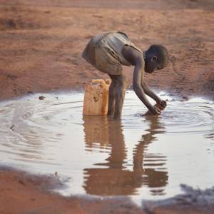 A girl fills a container with muddy water in the Ajuong Thok Refugee Camp in South Sudan. (Photo by Paul Jeffrey/ACT)