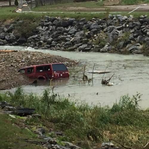 A pickup truck is left partially submerged in the aftermath of flooding in West Virginia. (Photo by Phillip Darby)