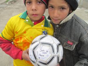 Roma youth excited to show off their new soccer ball signed by German & BFA Team members