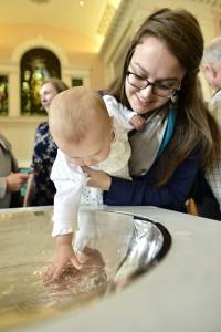 At Central Presbyterian Church in Louisville, Molly Atkinson holds her 10-month-old niece, Nora, as she touches her baptismal water. —Photo by Paul Atkinson 