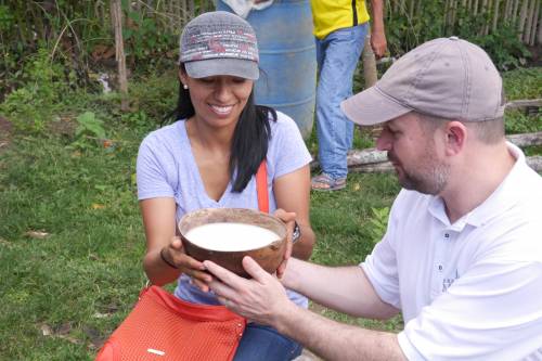 Jenny receives a bowl of masato from Richard Williams, the Young Adult Volunteer Program coordinator, who traveled with Jenny to Tununtunumba. Masato is a traditional drink prepared by the mashing and fermenting of yuca. The community serves it to all visitors as a way to welcome guests and build trust. PHOTO CREDIT: Daniel Pappas, Young Adult Volunteer in Peru.