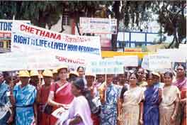 Women demonstraing and holding up Chethana signs.