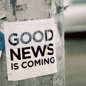 Sign attached to pole that reads: Good News is Coming