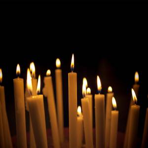 A bunch of lit candles against a black background.