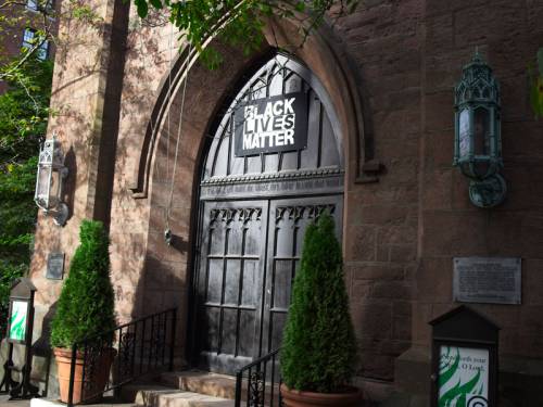 A Black Lives Matter sign over a church door entrance.
