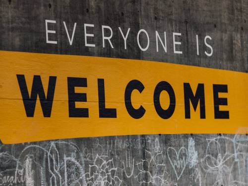 Sign painted on wall that reads: Everyone is Welcome