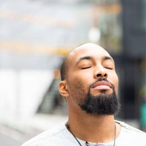Man with eyes closed is relaxing and meditating