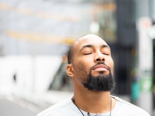 Man with eyes closed is relaxing and meditating