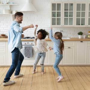 Father and his two children dancing in their kitchen
