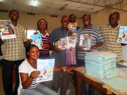 Simon Ntumba (second from right) and other staff at Improka show the pictures that were included in the Sunday School lesson book
