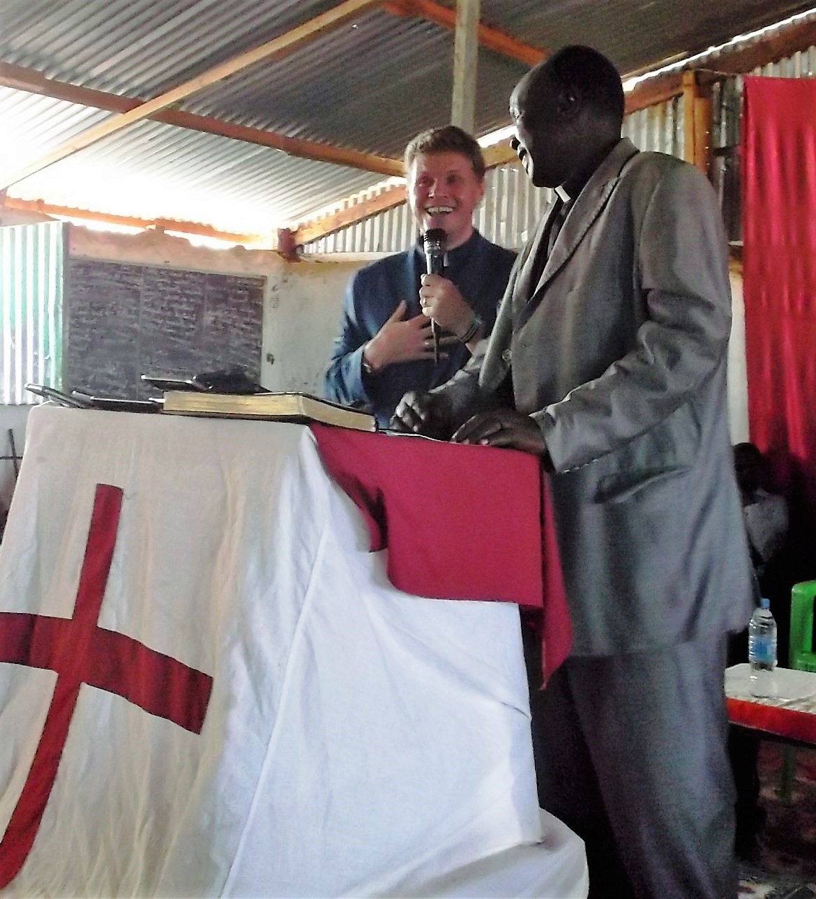 Bob preaches at a large church in the refugee camp, while Pastor Peter translates into Nuer.