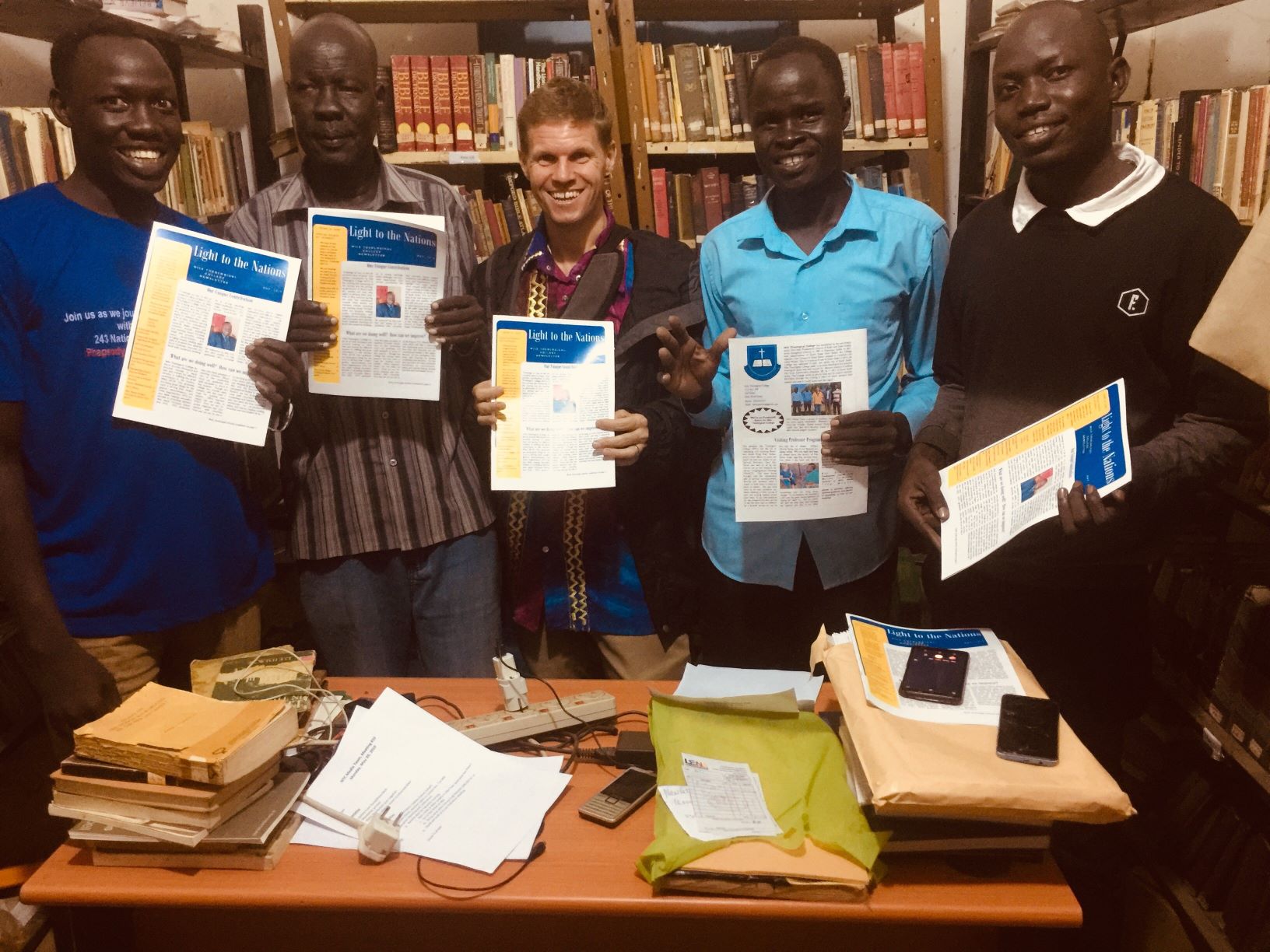 The Media Team at Nile Theological College proudly displays the newsletter they produced.