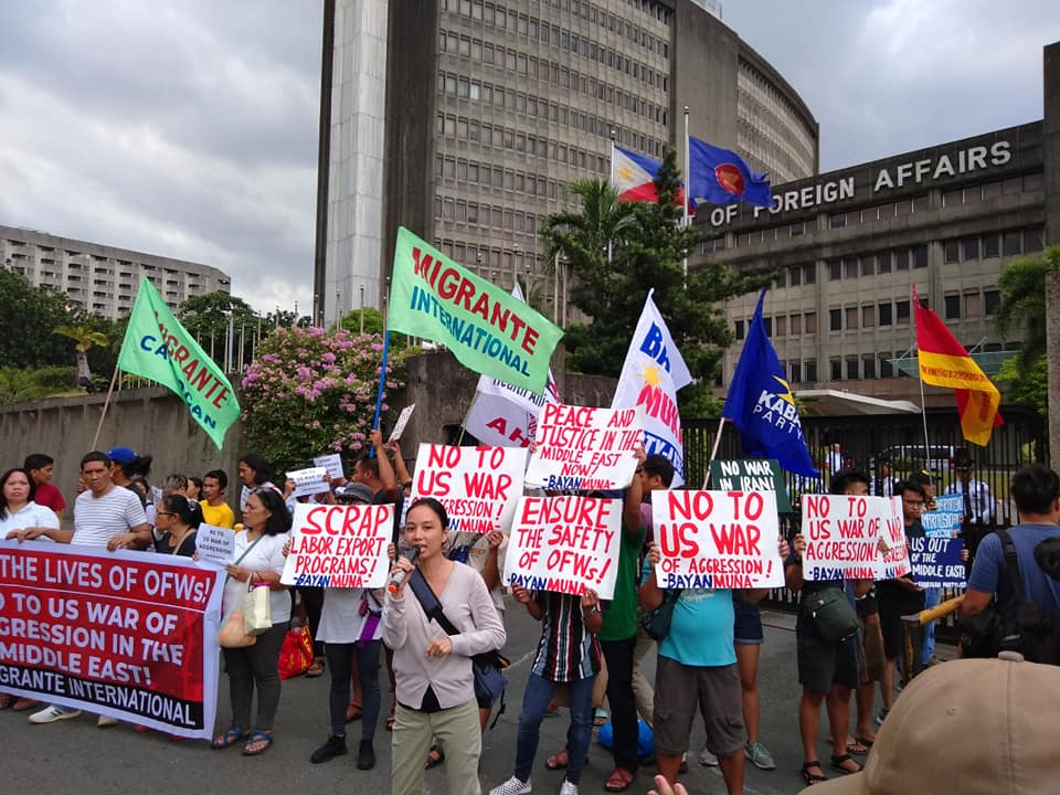During an action in front of Philippine Department of Foreign affairs calling for protection of OFWS during US-Iran conflict – Joanna is pictured with a microphone.