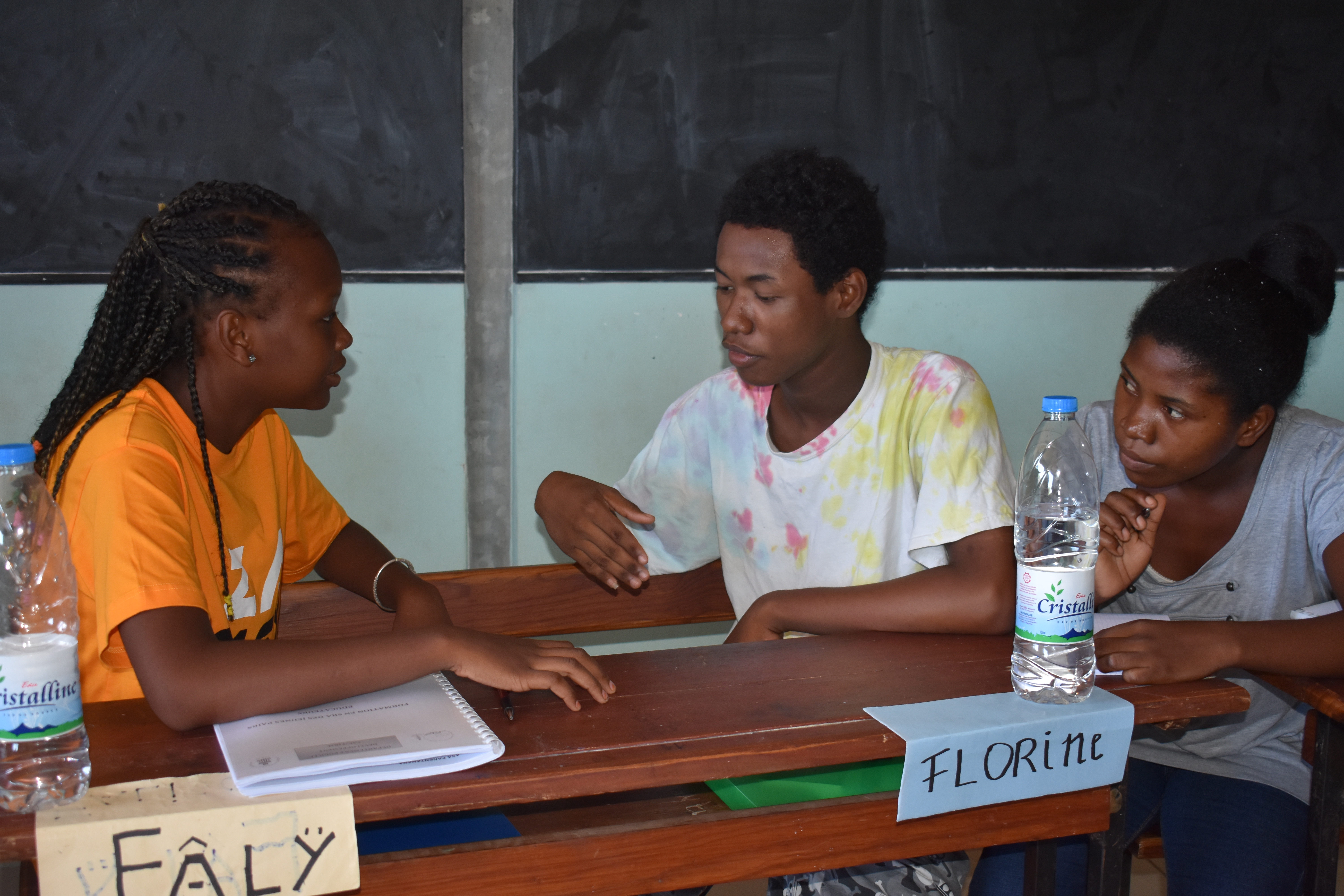 Youth peer educators practicing one-on-one sharing during training.