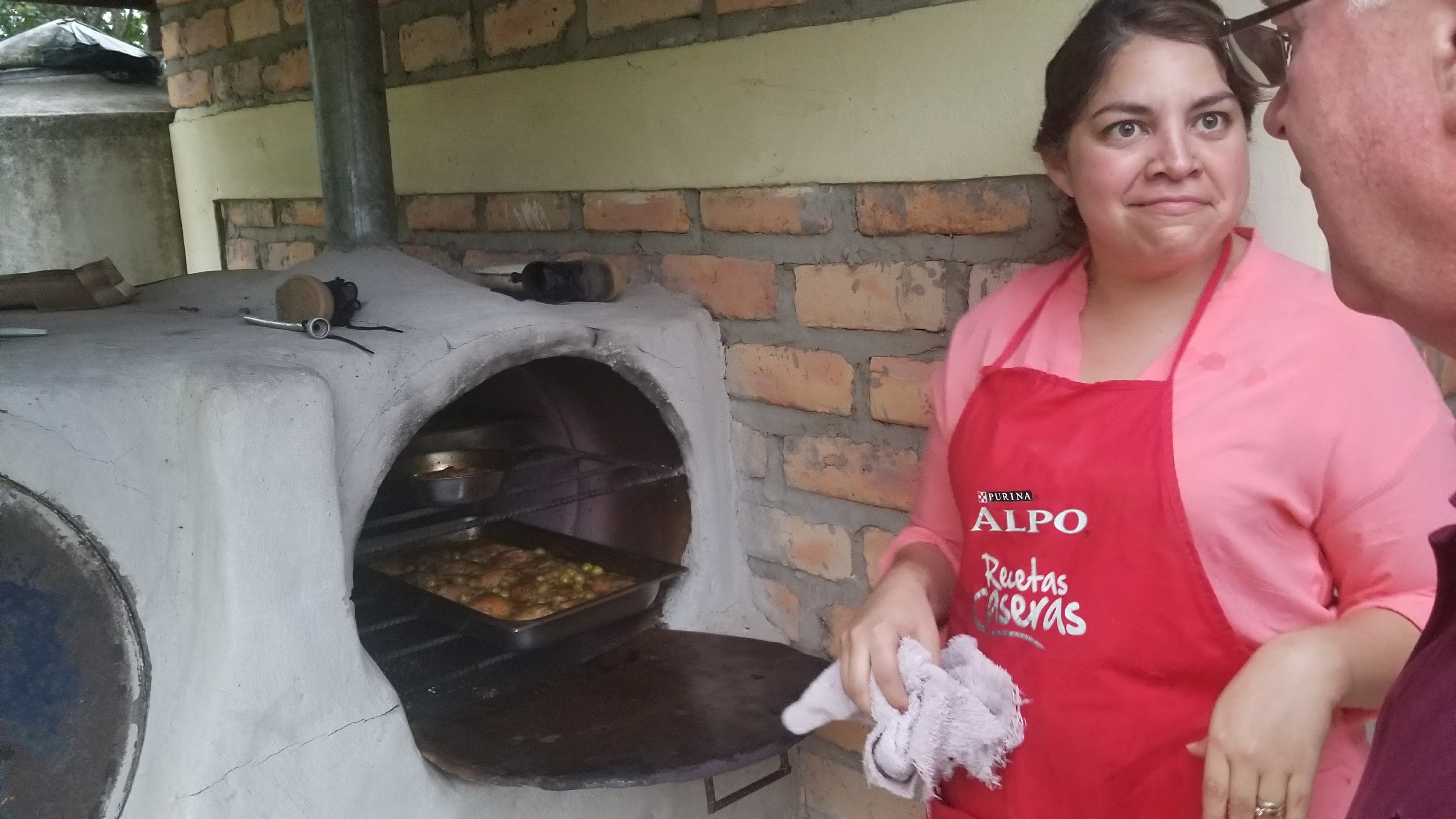 Volunteer Director Selenia Ordoñez uses the outdoor wood-fired oven at Villa Gracia.