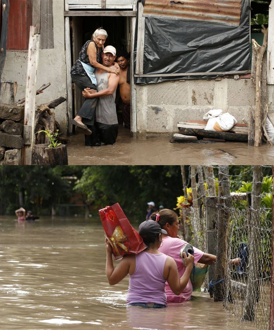 People leaving their houses that have been flooded by the local river after the passing of hurricanes Eta and Iota