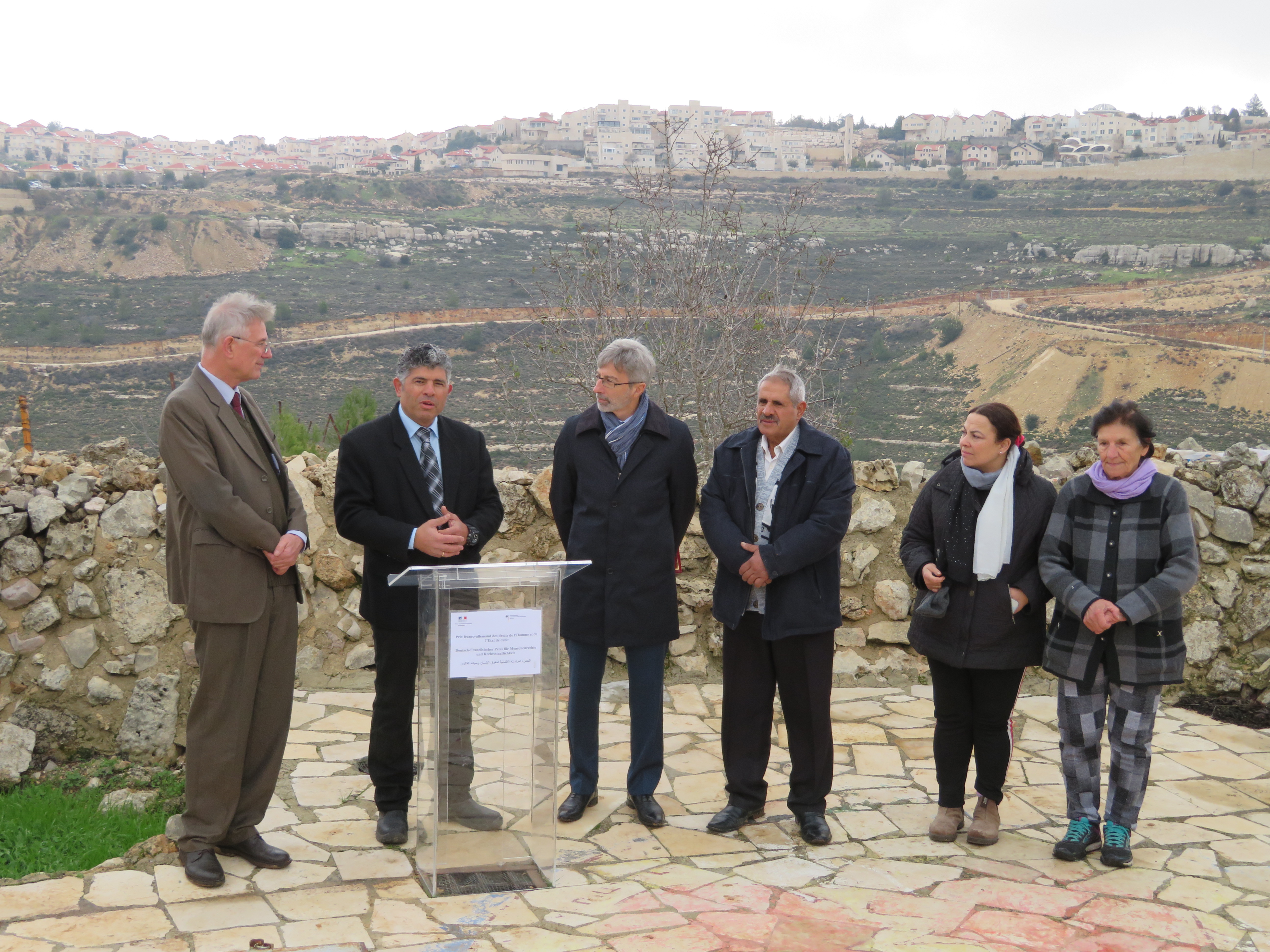 The Nassar family receives a joint French/German peace prize for their work for peace and non-violent resistance. The Israeli Settlement of Newe Daniel sits on the hilltop behind. Photo: Doug Dicks