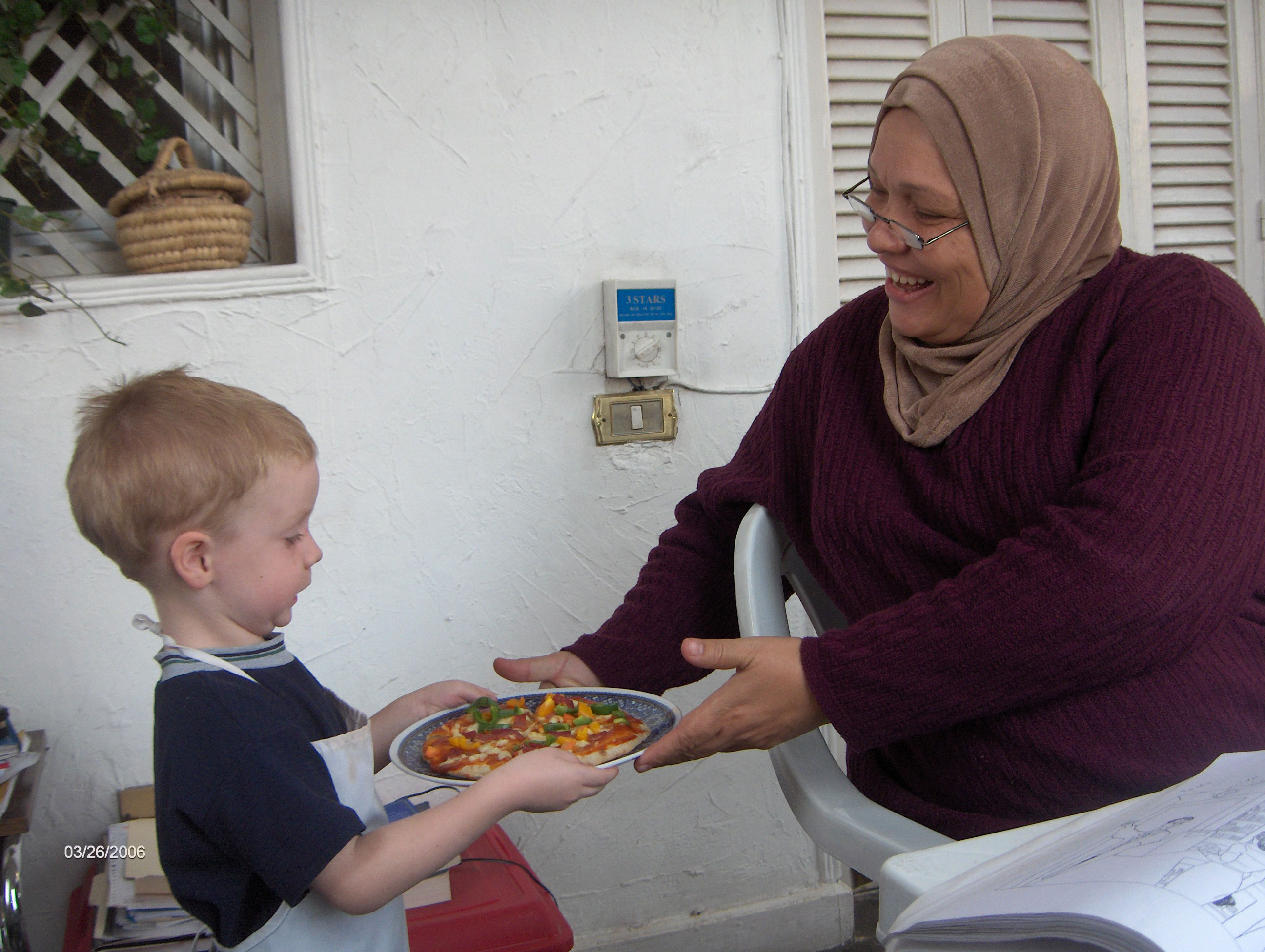 Christopher serving pizza to Ashgaan, our Arabic tutor, on our balcony