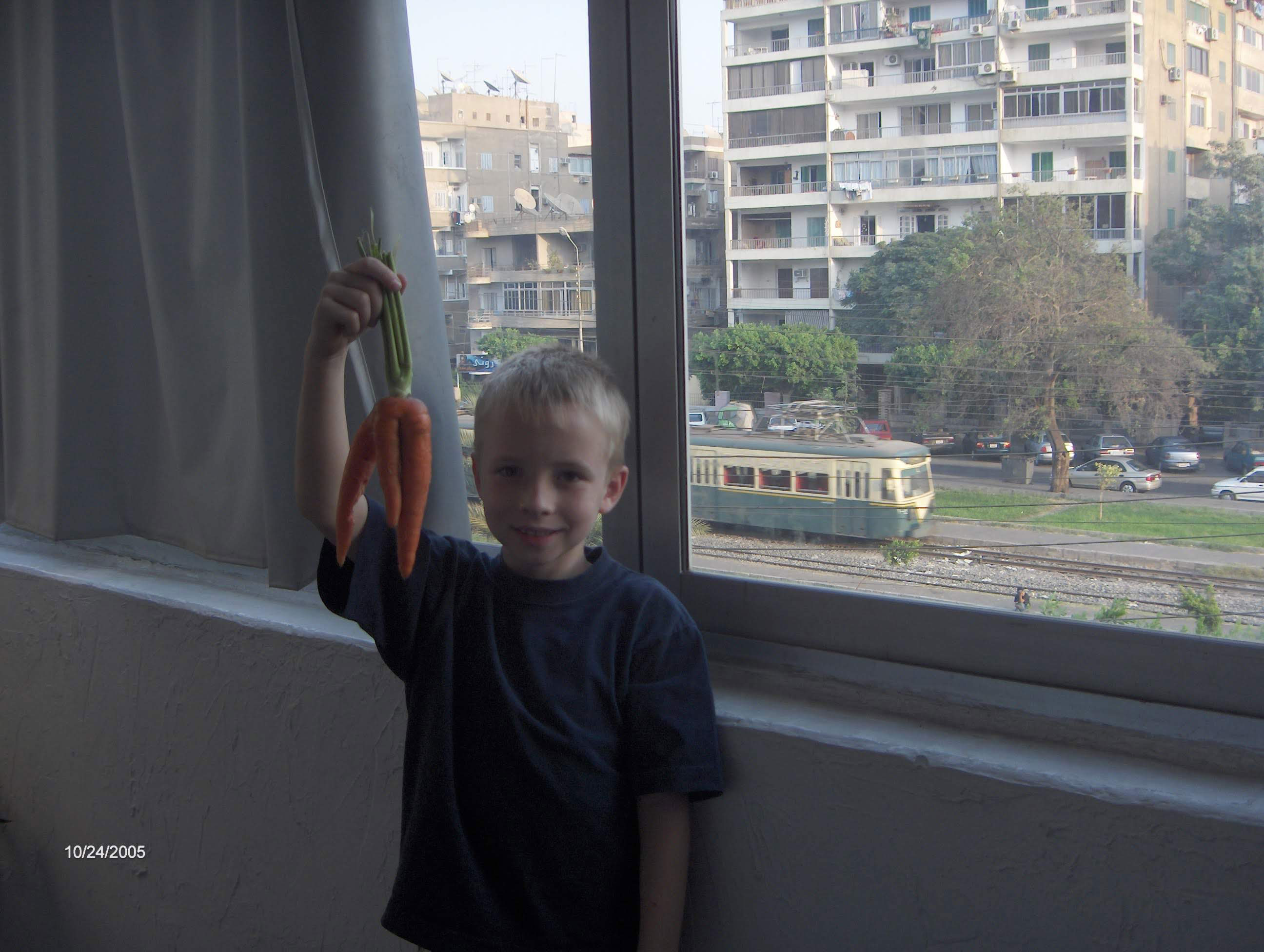 Clayton with “alien carrots” on our balcony overlooking the local metro train tracks