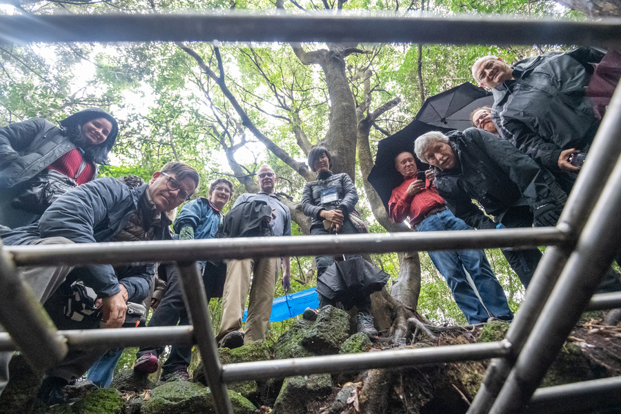 2018 Presbyterian Peacemaking Travel Study Seminar participants looking into the entrance of Seonheul Doteul Cave, where Jeju Island citizens hid, and were ultimately killed, during the April 3 Uprising and Massacre. (Photo by Gregg Brekke)