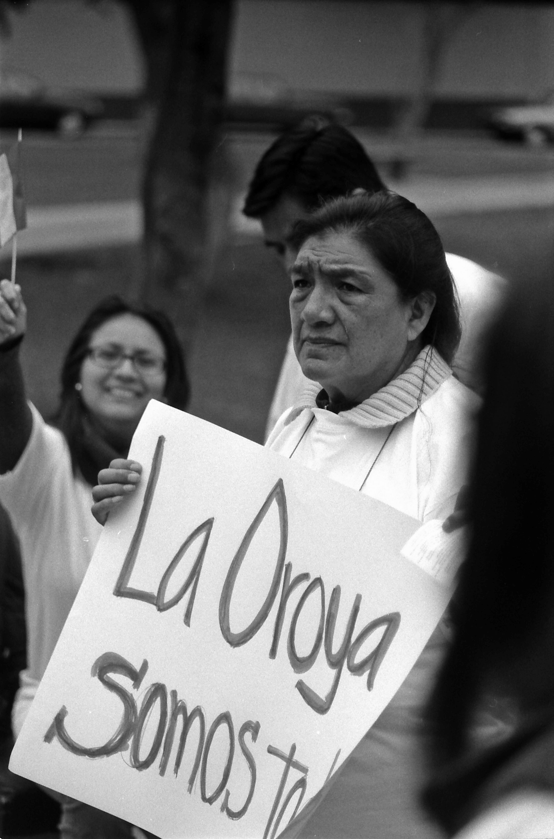 Esther Hinostroza speaks out at a demonstration, holding a sign that reads, ¨We are All La Oroya.¨ (photo by Jed Koball, circa 2010)