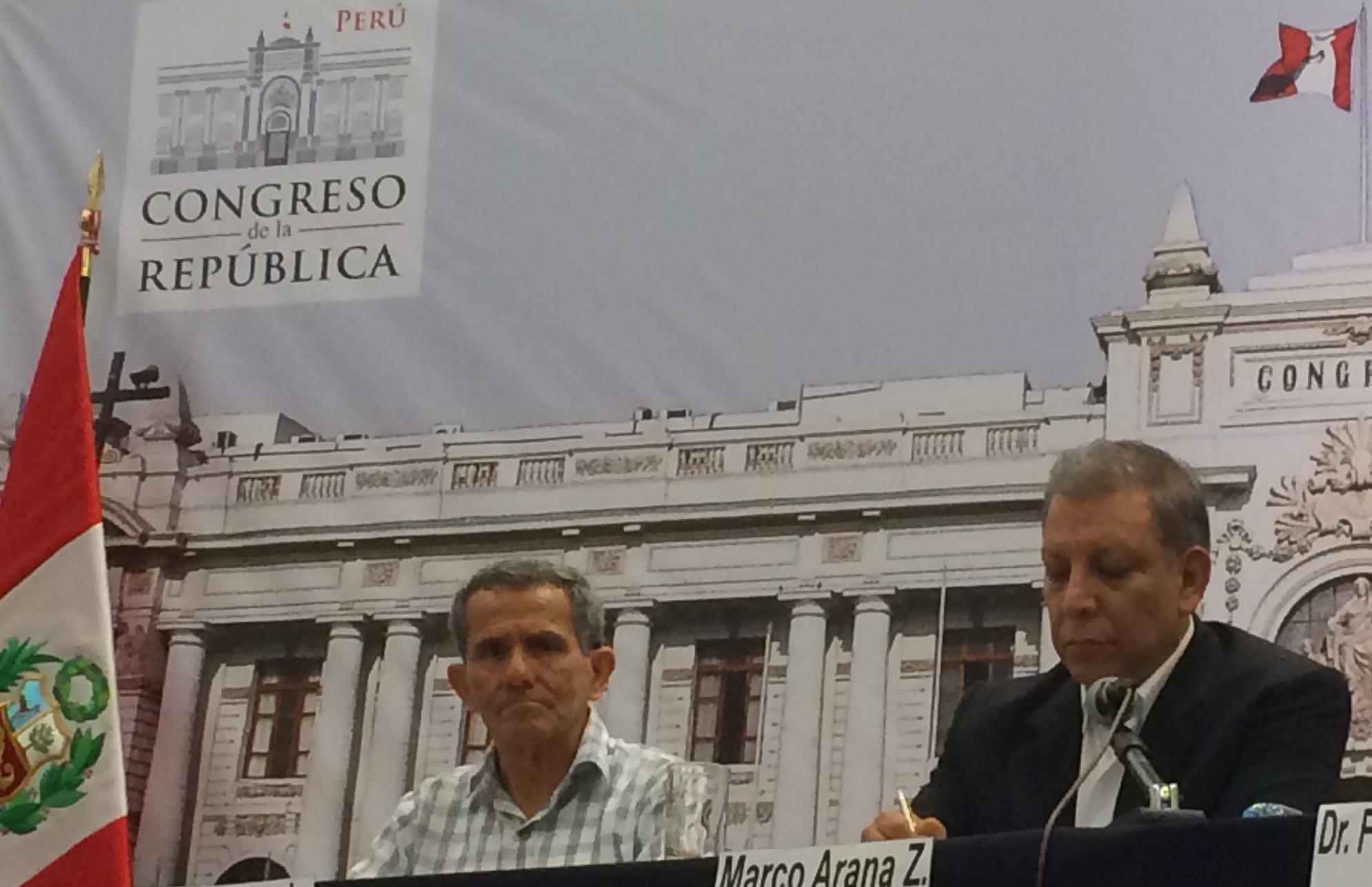 Conrado Olivera (director of Joining Hands network in Peru) sits alongside Representative Marco Arrano at the Peruvian Congress as they make their case for a national Environmental Health program (photo by Jed Koball)