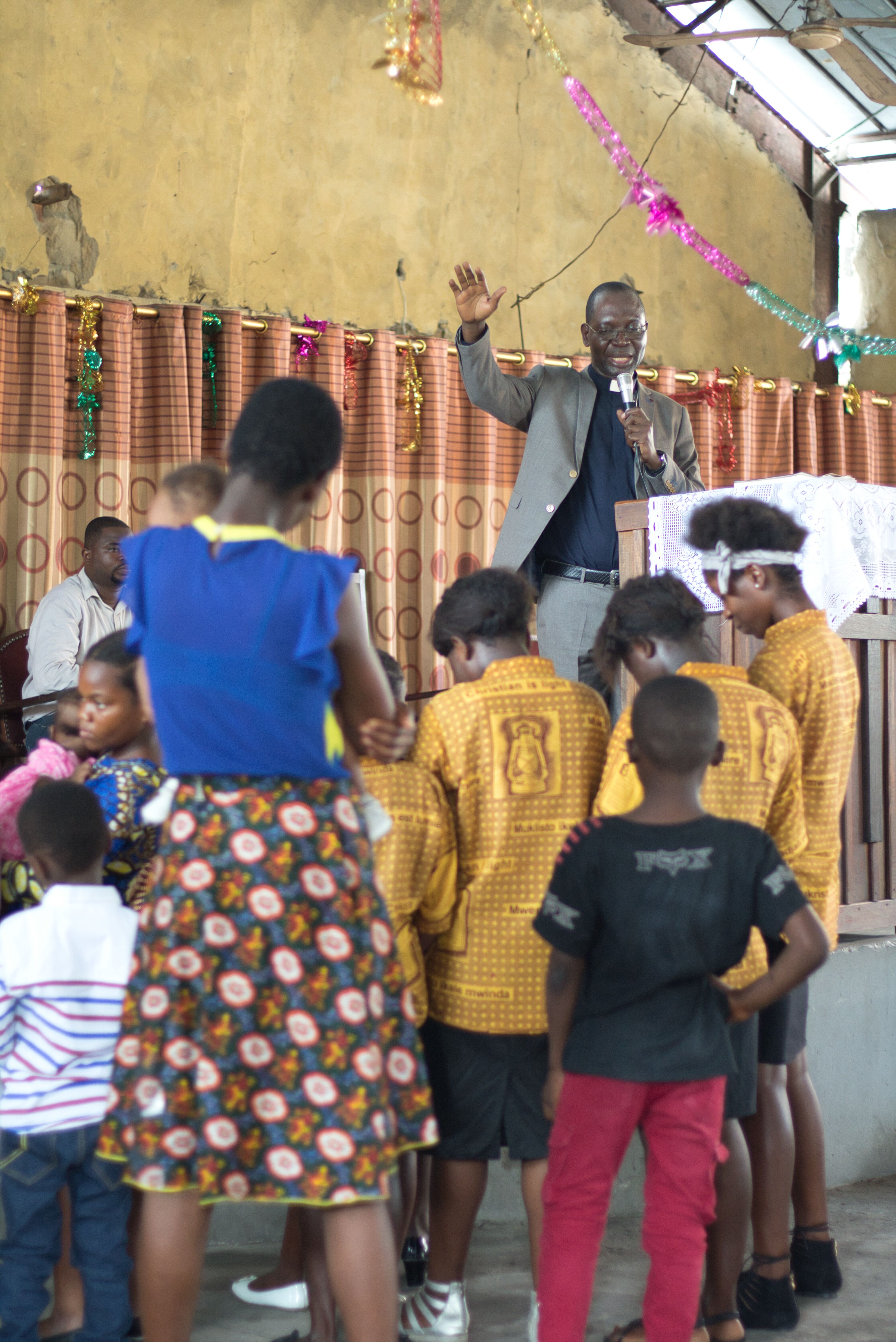 Mindful of end-of-the-school-year exams, Pastor Isaac blesses children during worship service.
