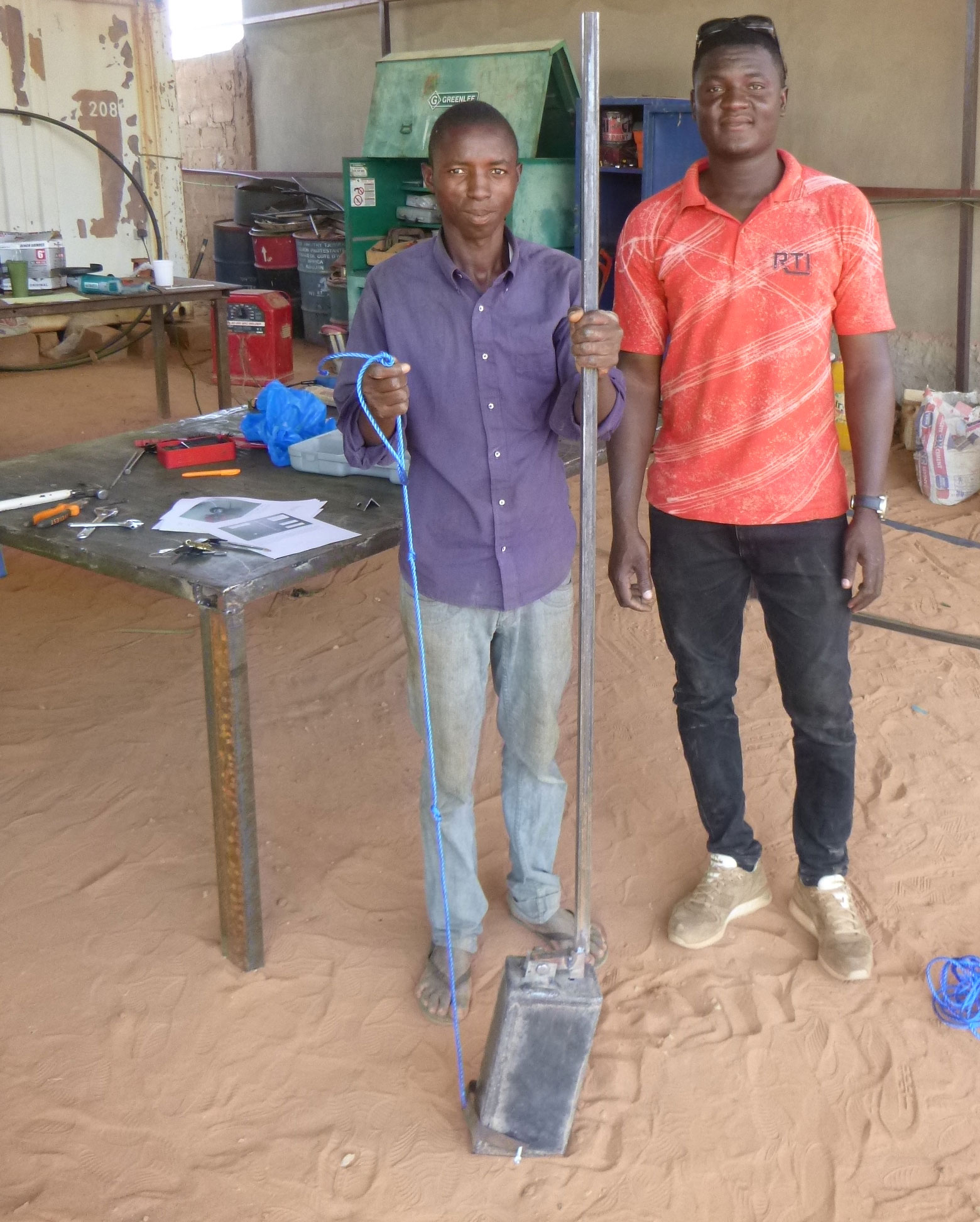M. Hachimou Kadade (left) and Amos Mohammedou are at the SMART Centre displaying the Sludge Digger they fabricated together.