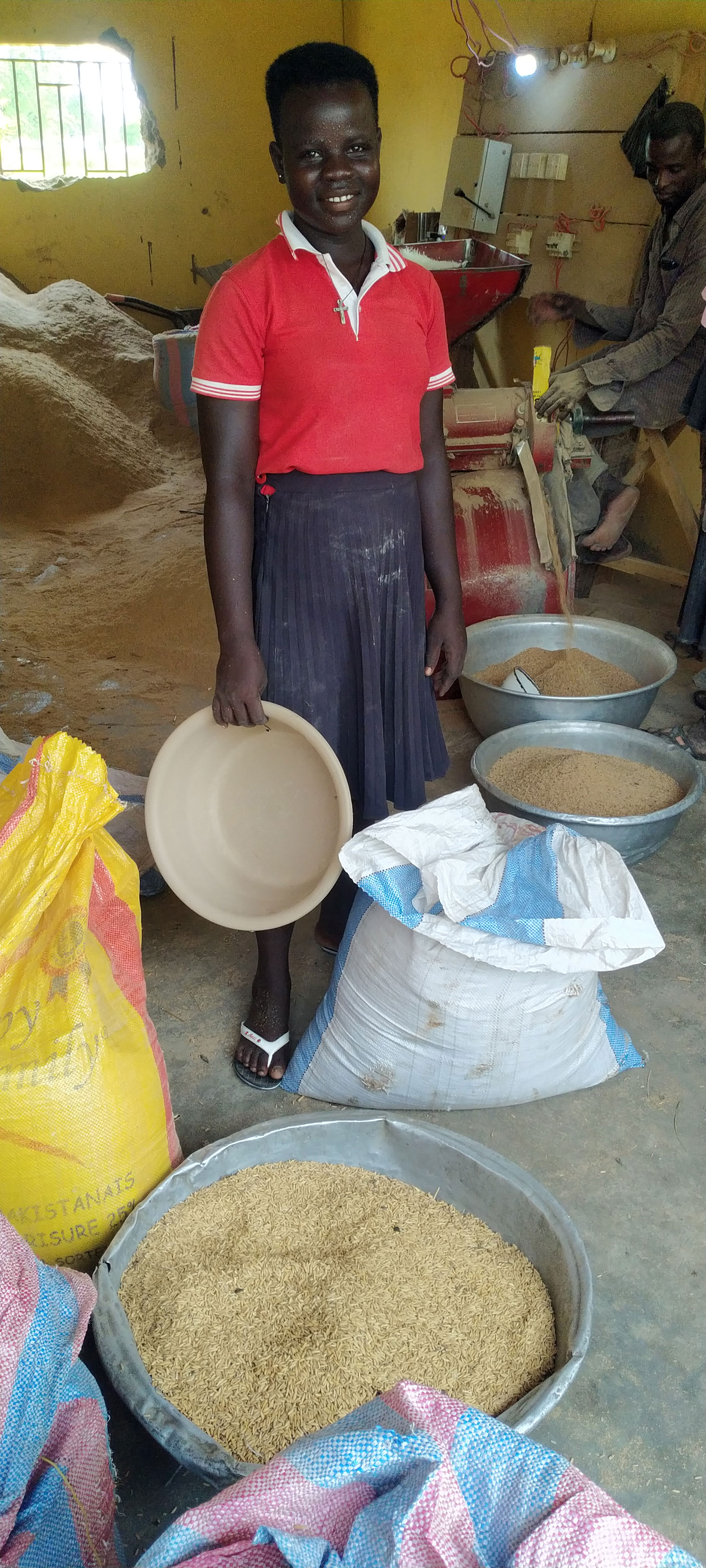 A high school student brings her family's rice to be milled.