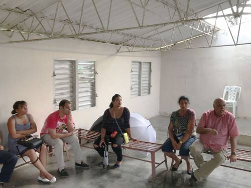 Edelberto Valdes (right) talks with mission leaders at CANIP in their storm-damaged chapel. (Photo by Randy Hobson)