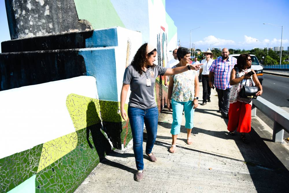 Mariolga Juliá Pacheco, manager of special projects for Fideicomiso de la Tierra del Caño Martín Peña, leads a tour on the bridge over the canal for representatives of the Compassion, Peace & Justice ministries of the Presbyterian Mission Agency. (Photo by Rich Copley)