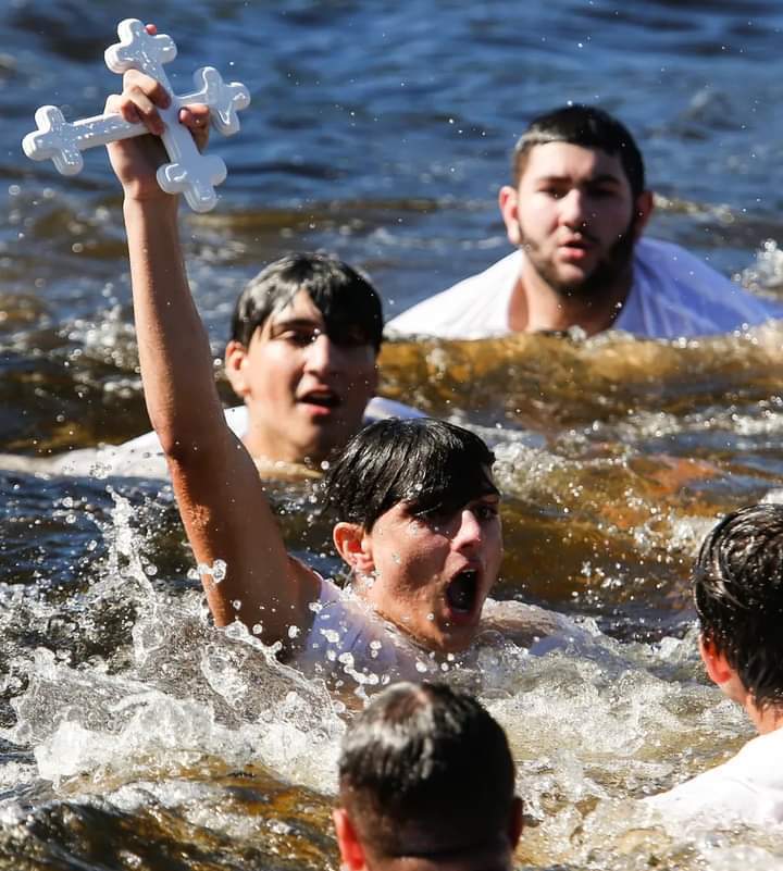 Celebrating the Epiphany tradition. The priest throws a cross into the sea. Whoever swims fastest and catches the cross is the blessed winner.