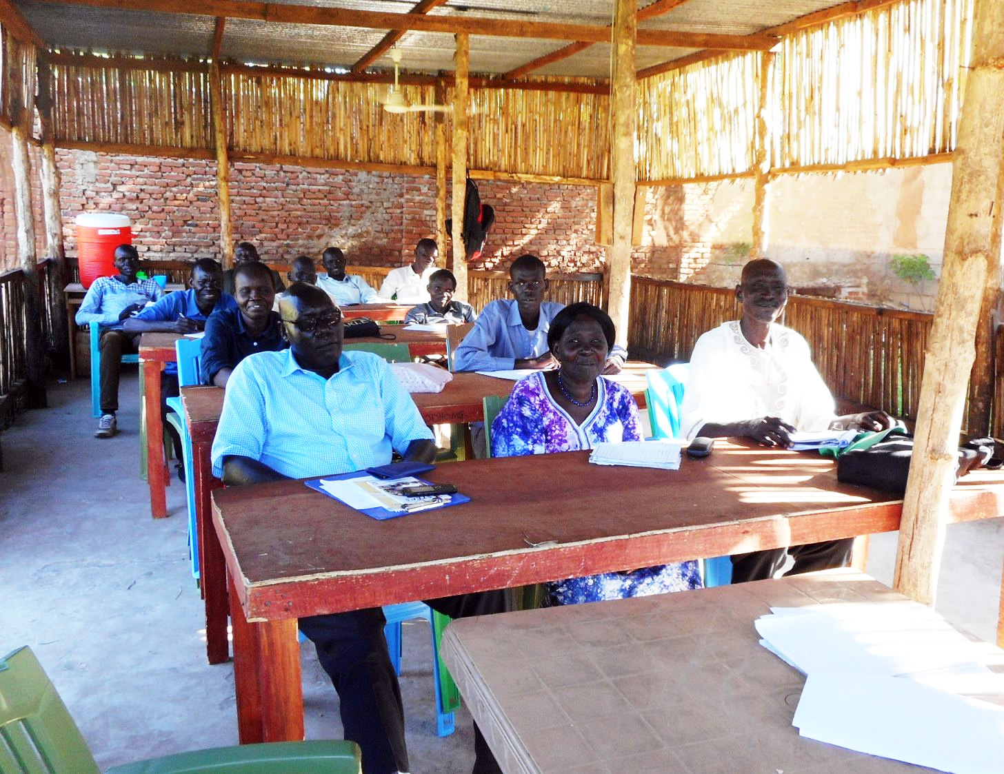 Students in class in a new temporary classroom at Nile Theological College.